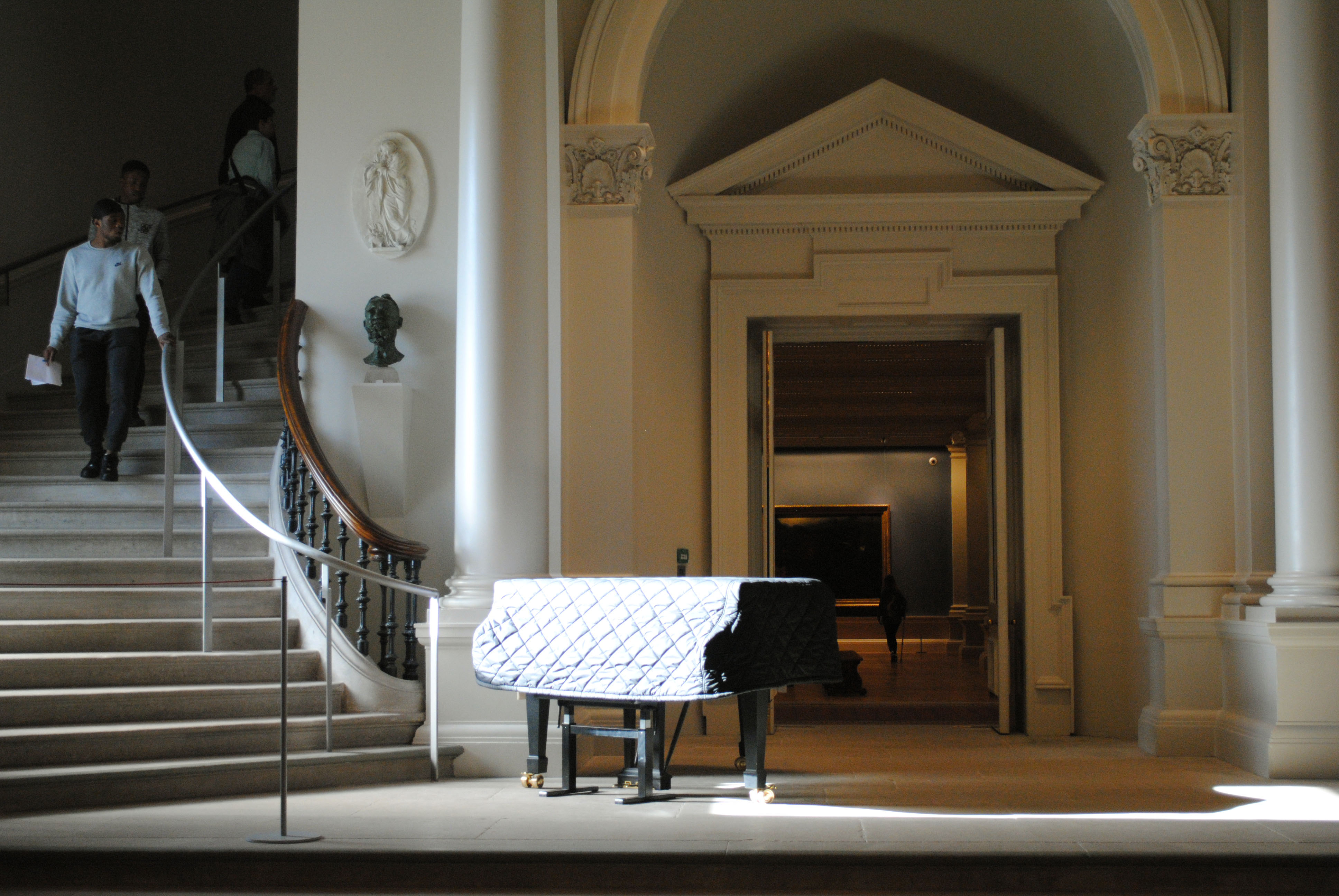 Visitors descend from upper galleries to a piano at the top of the Shaw Room.